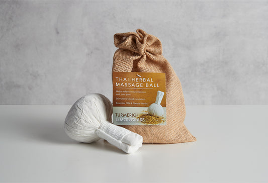White Thai herbal massage ball in burlap pouch with turmeric and lemongrass label.