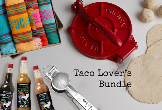Red tortilla press, colorful striped kitchen towels, habanero hot sauces, measuring spoon, and flour tortillas displayed toge