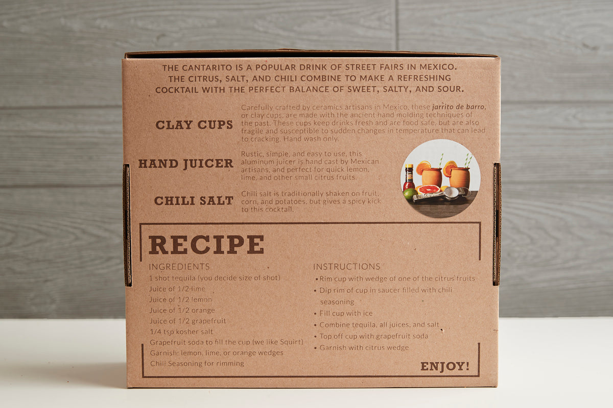 Brown cardboard kit box with printed instructions for Cantaritos cocktail, clay cups, hand juicer, and chili salt included.