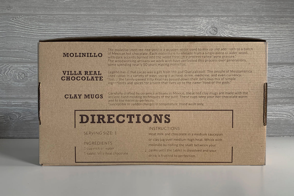 Kraft cardboard box containing Mexican hot chocolate set with molinillo whisk, Villa Real chocolate, and clay mugs, printed w