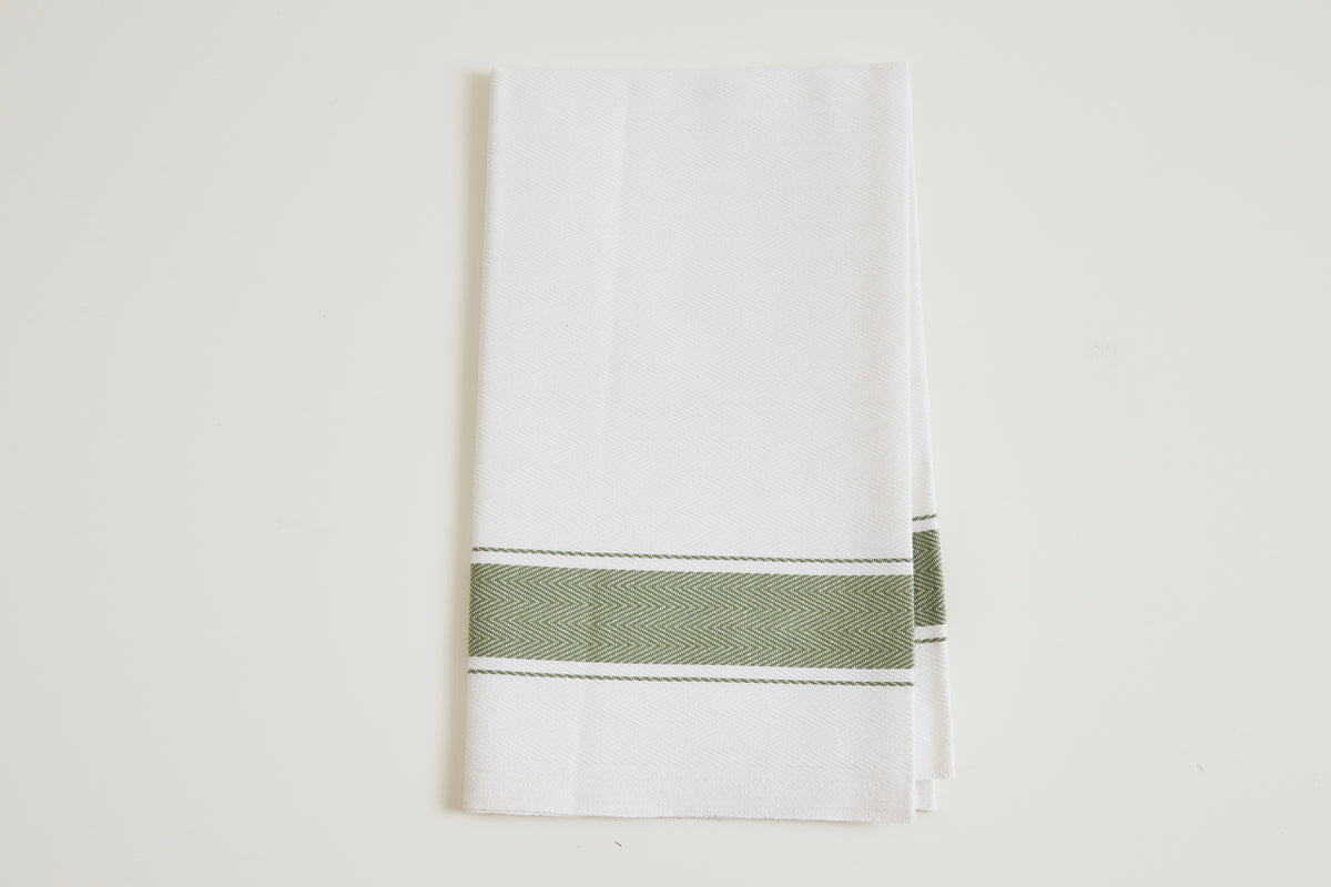White cotton kitchen towel with green herringbone stripe band across center and white topstitching.