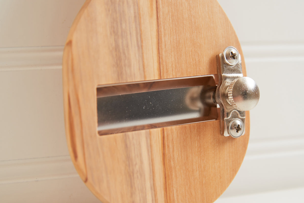 Light wood truffle slicer with metal adjustable blade and silver knob mechanism mounted on oval base.