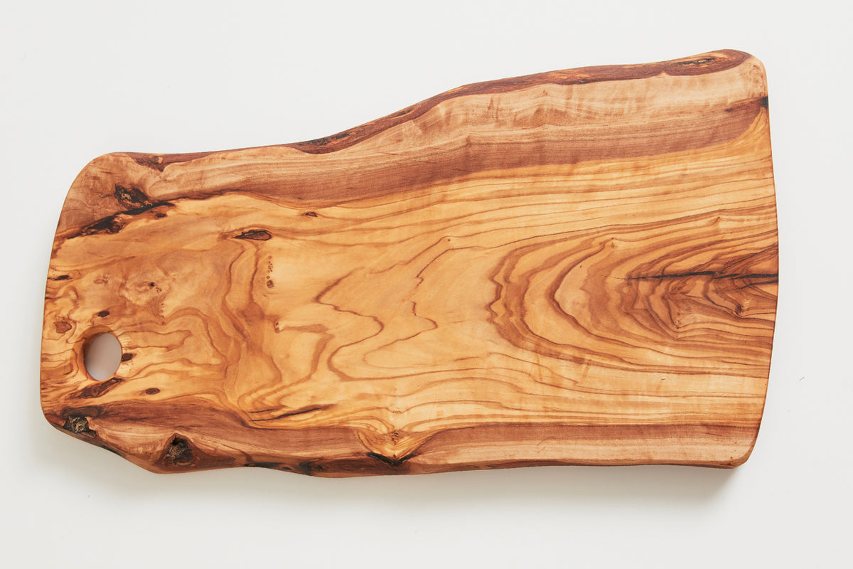 Rectangular olivewood charcuterie board with natural grain patterns, dark knots, and a circular hole near one end for hanging