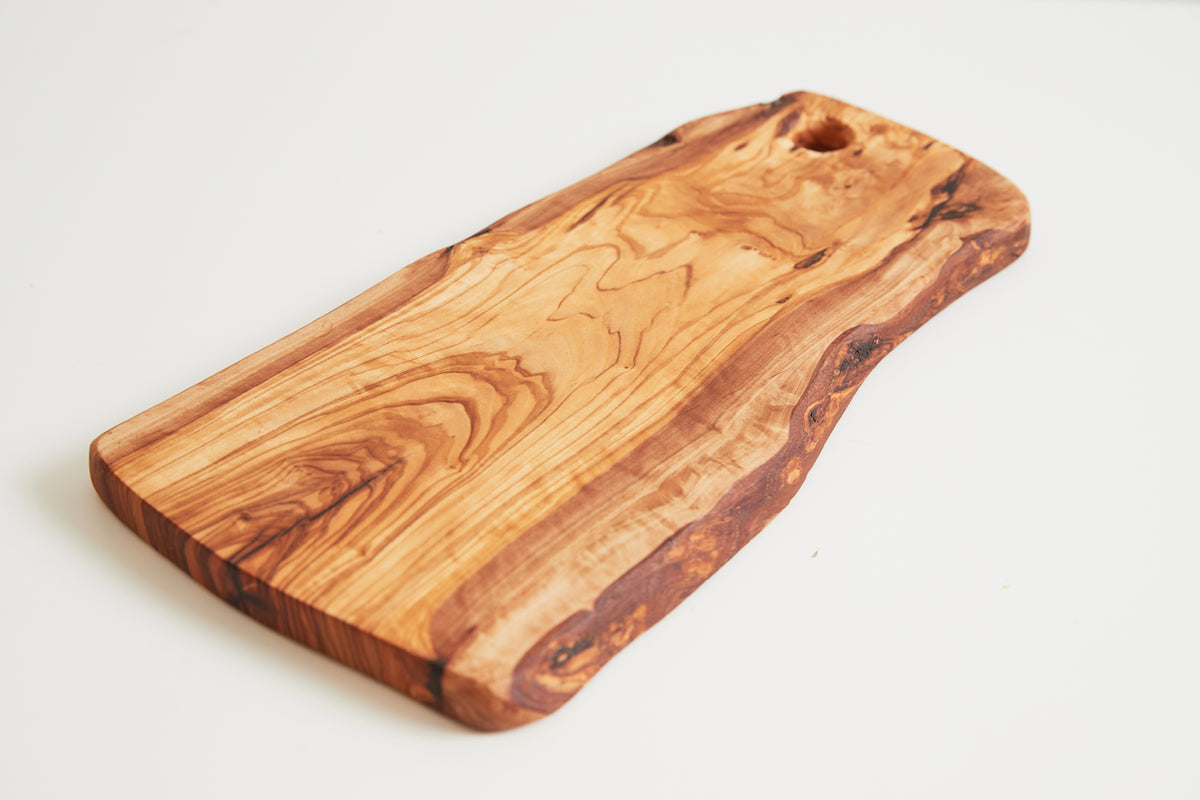Rectangular olive wood charcuterie board with natural grain patterns and a hole for hanging.