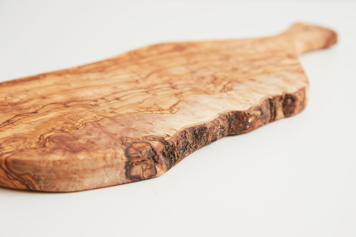 Wooden charcuterie board with natural grain patterns and a paddle-style handle.