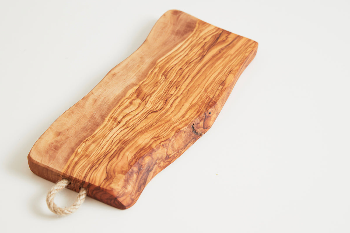 Rectangular olivewood board with natural grain patterns and a rope handle attached to one end.