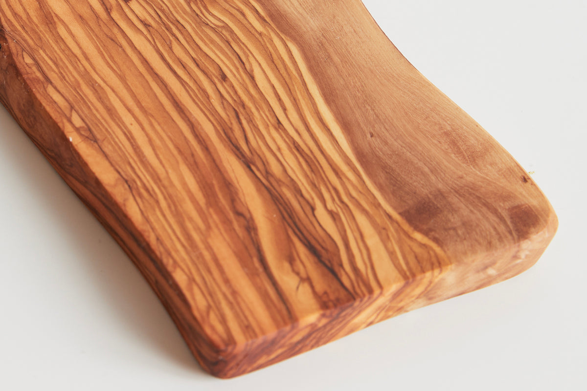 Rectangular olive wood board with natural grain patterns and rounded corners, shown at an angle.