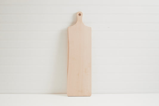 Light wood serving board with handle hole, rectangular shape on white background.