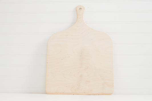 Light wood pizza peel with handle and rounded square paddle on white background.
