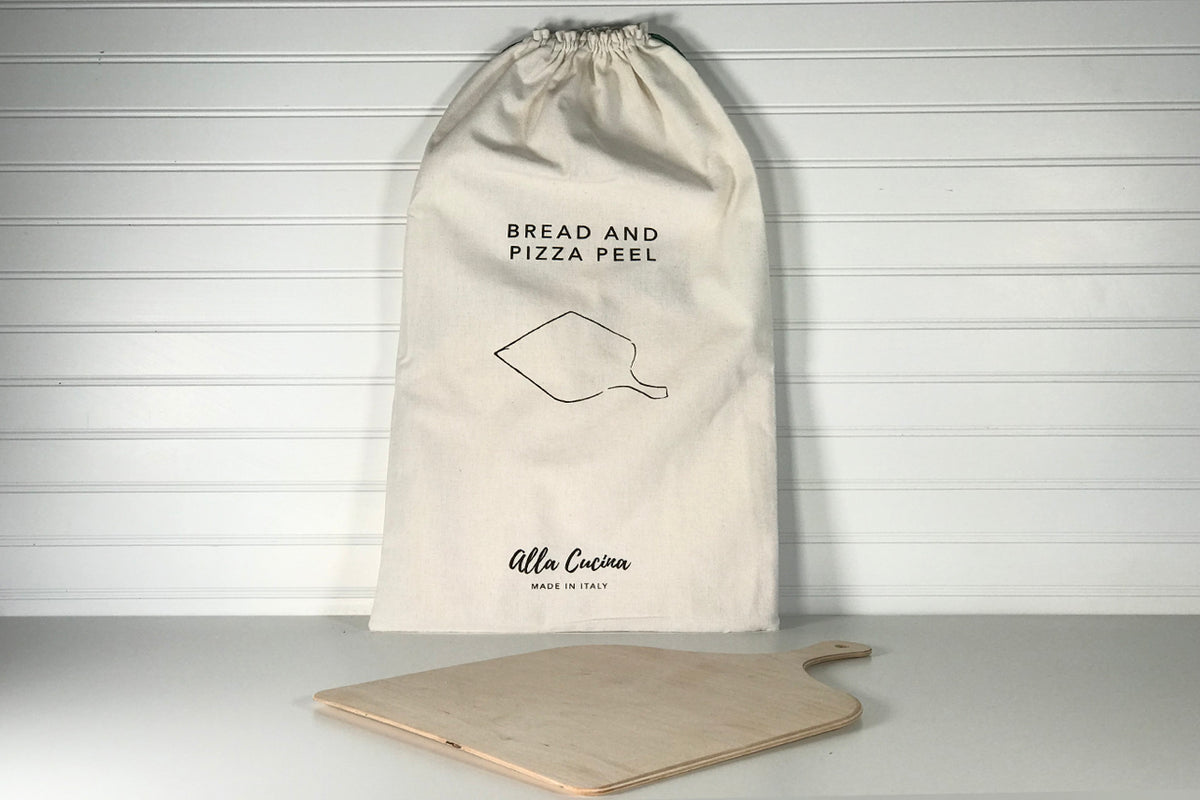 Cream drawstring bag labeled "Bread and Pizza Peel" with wooden pizza peel displayed in front.
