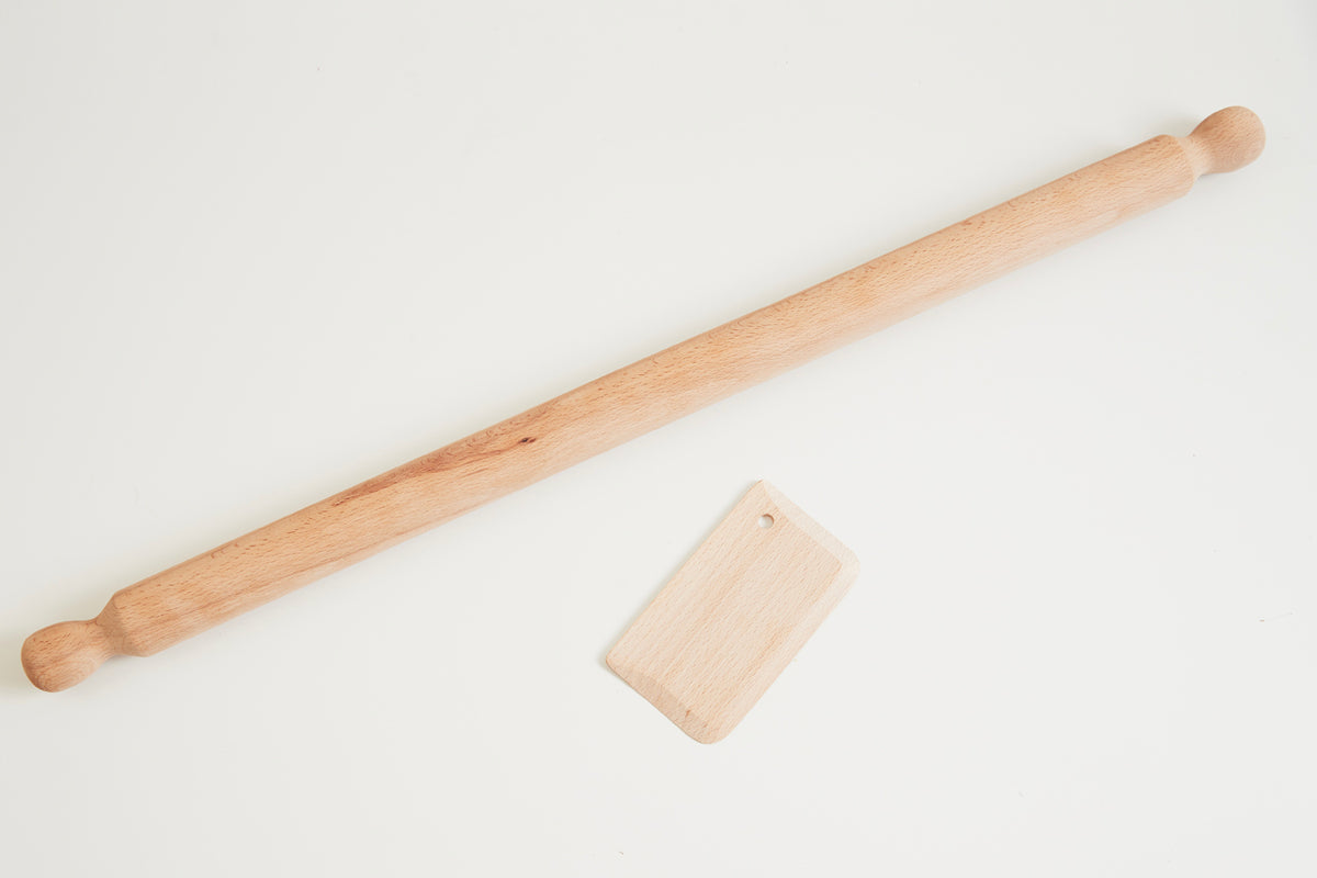 Wooden mattarello rolling pin with handles and rectangular dough scraper on white background.