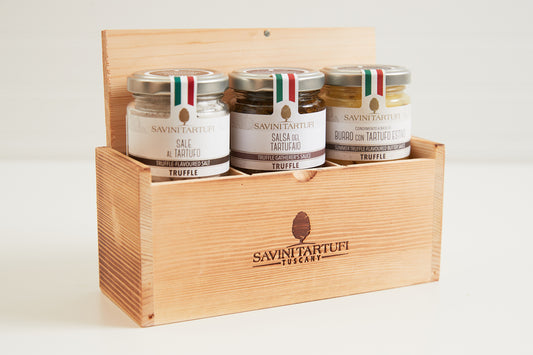 Wooden gift box containing three glass jars of Savini Tartufi truffle products with Italian flag-striped metal lids.