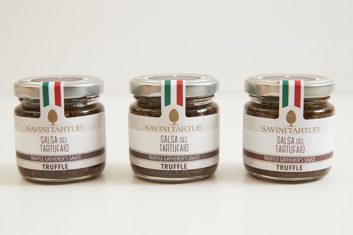 Three glass jars of Savini Tartufi truffle sauce with cream and green-white-red Italian flag labels.