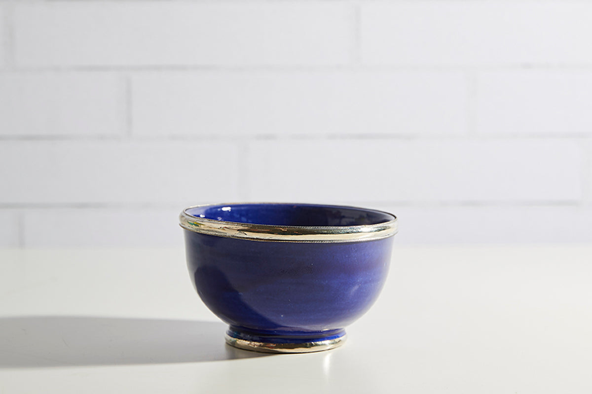 Deep blue glazed bowl with metallic gold trim around rim and base.