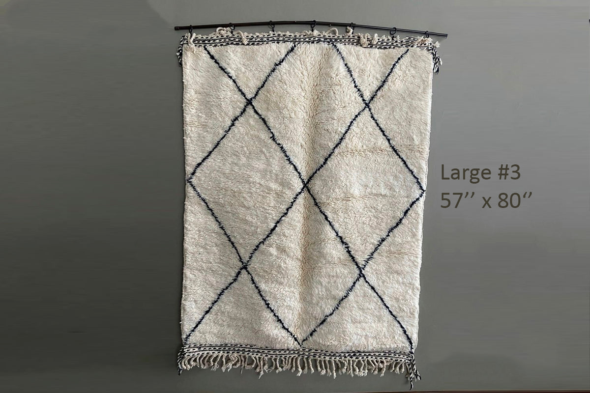 Cream wool rug with black diamond lattice pattern and fringe trim on short ends, 57" x 80".