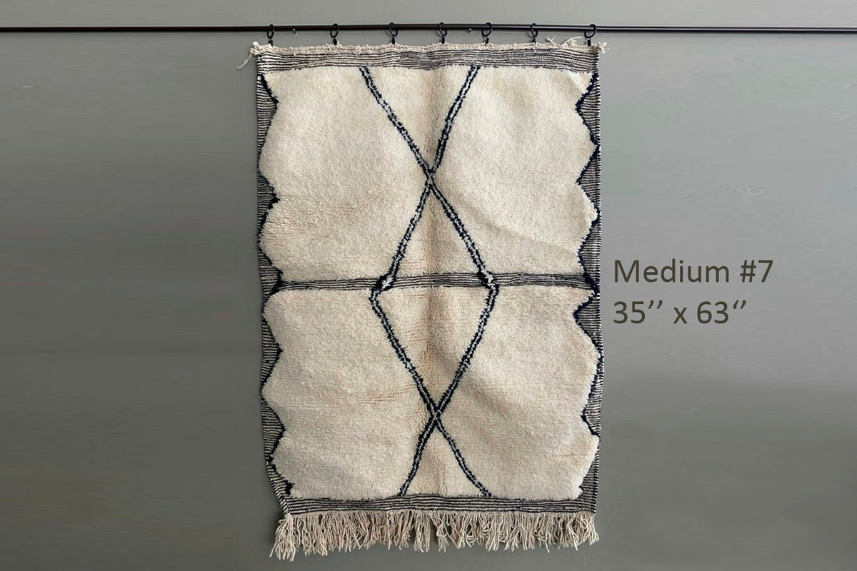 Cream and navy Berber rug with geometric diamond pattern and fringe trim, 35" x 63".