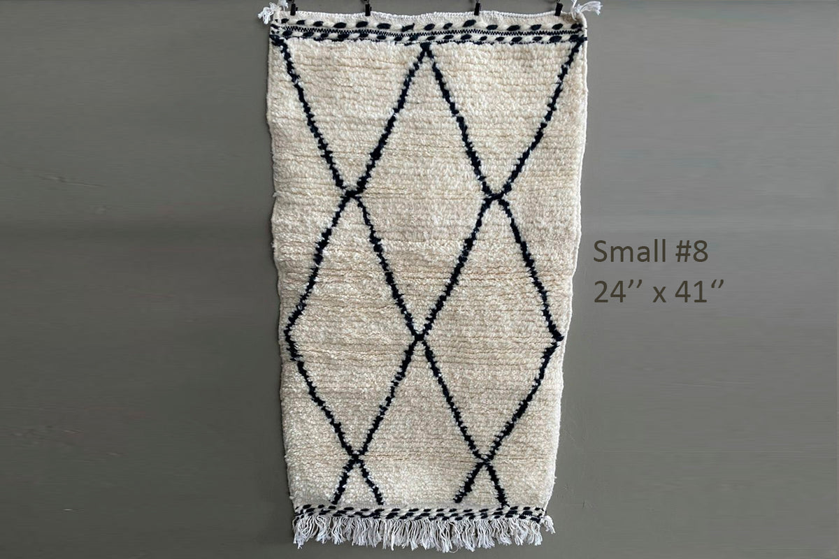 Cream wool rug with black diamond pattern and fringe ends, 24" x 41".