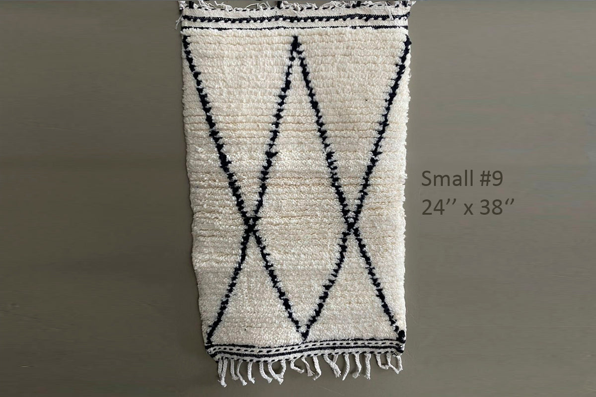 Cream wool rug with black diamond pattern and fringe ends, 24" x 38".