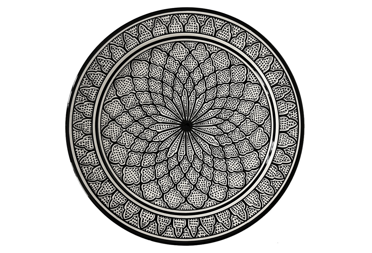 Round ceramic platter with black and white geometric mandala pattern and concentric borders.
