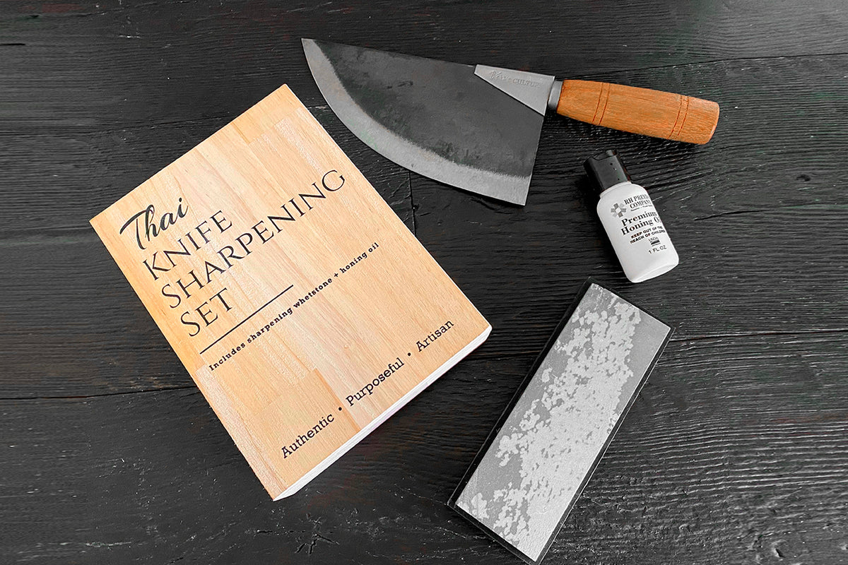 Thai knife sharpening set with wooden instruction guide, ceramic honing stone, whetstone, and curved blade knife with wooden 