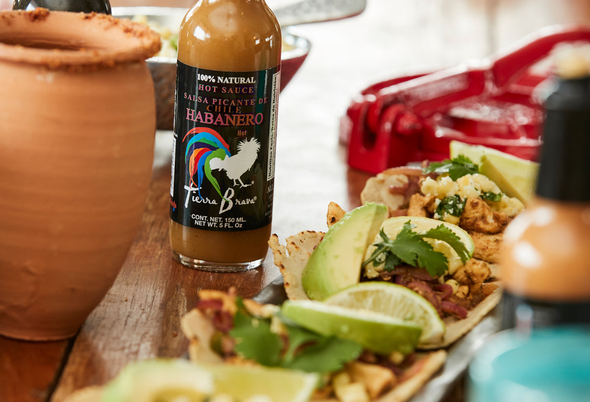 Tierra Brava habanero hot sauce bottle with black label and colorful rooster logo, 250 ml size.