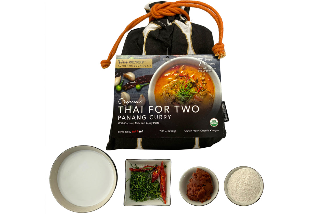 Organic Panang curry kit with black cloth pouch containing coconut milk, curry paste, and fresh herbs in separate bowls.