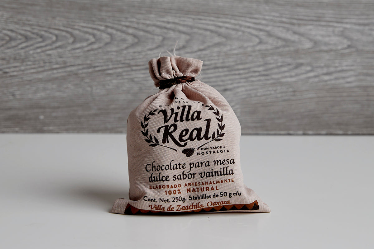 Villa Real Mexican hot chocolate in tan cloth pouch with black text and wreath design, 250g net weight.