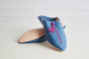 Blue leather slippers with pink tassels and beige suede lining.